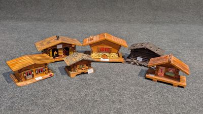 cinq petites maisons en bois posées par terre