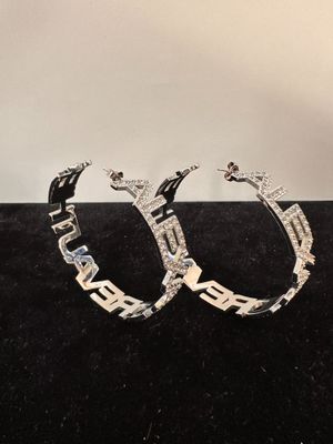 a pair of diamond hoop earrings on a black velvet surface