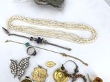 a lot of jewelry on a white plate on a table