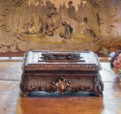 une boîte en bois posée sur une table, à côté d'un vase de fleurs