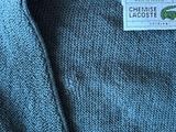 the back of a blue sweater with a label on it