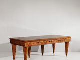a wooden table with two legs and a black top on a white surface