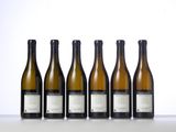 six bottles of wine are lined up on a table