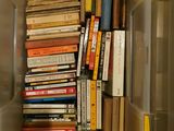 many books in a plastic box on the floor