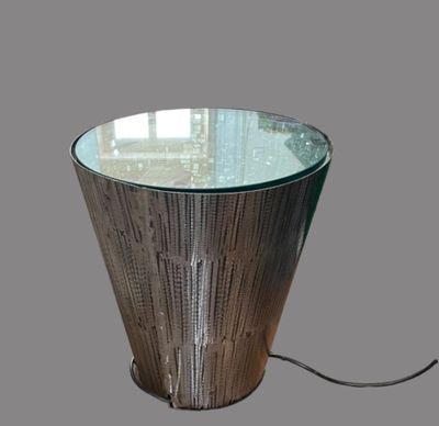 une table avec un plateau en verre et un piètement en métal