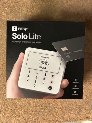 un gros plan d'une personne tenant une carte de crédit devant une boîte