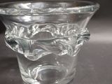 a clear glass vase with a handle on a table