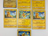 Plusieurs cartes Pokémon sont disposées sur une surface blanche