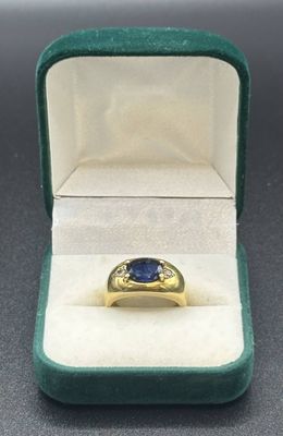 a yellow gold ring with a blue sapphire stone in it