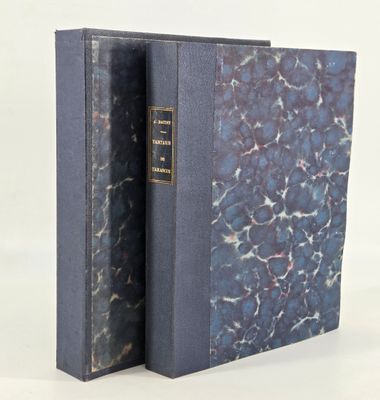 an old book with a blue cover sitting on top of a white table