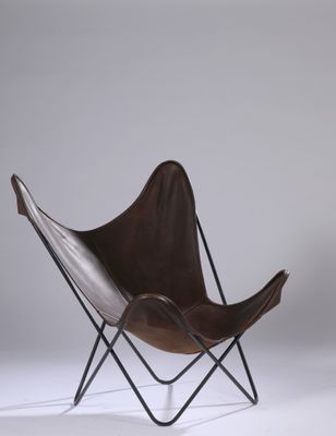 fauteuil papillon en cuir avec des pieds en métal noir et une assise en cuir marron