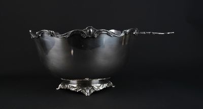 a silver bowl with a spoon in it on a black background