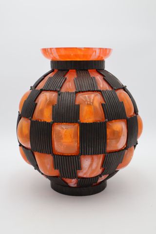 Vase boule en verre orangé enchâssé dans une monture fer martelé,...