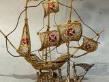 maquette en laiton d'un voilier arborant une croix rouge sur ses voiles