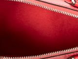 the inside of a red handbag with zippers on it