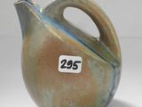 un vase marron et bleu sur lequel est accrochée une étiquette