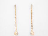 une paire de boucles d'oreilles plaquées or sur fond blanc