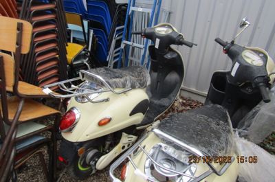 un scooter garé à côté d'une pile de chaises