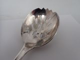a silver spoon with a black handle on a white surface