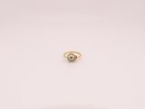 une photo d'une bague ornée d'une seule perle posée sur un fond blanc