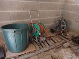 two buckets and a hose on a pallet in a room