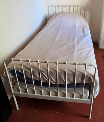 un lit blanc recouvert d'un drap blanc dans une chambre