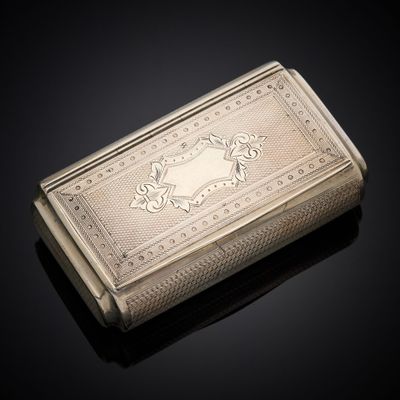 an antique silver cigarette case sitting on a black surface