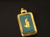 a close up of a gold pendant with a picture of a woman on it
