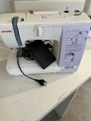 a white sewing machine sitting on a table with a power cord