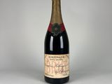 une vieille bouteille de vin posée sur une table blanche
