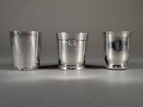three silver cups sitting on a table next to each other