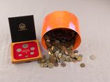 un petit récipient orange contenant des pièces et une boîte rouge renfermant une pièce