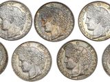 a group of six silver coins with heads of women on them