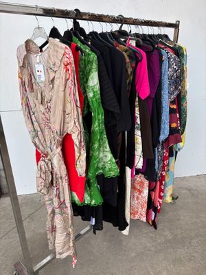 a lot of clothes hanging on a rack in a room