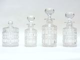 trois bouteilles en verre transparent posées les unes à côté des autres sur une surface blanche