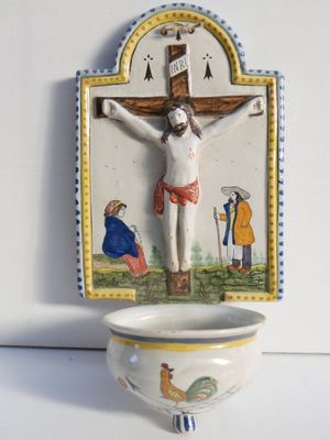 a picture of a crucifix on a wall above a bowl