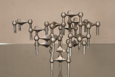 une sculpture métallique représentant un ensemble d'objets posés sur une table