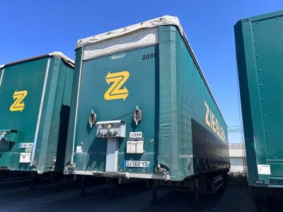 deux semi-remorques vertes garées côte à côte sur un parking