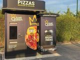 two pizzas that are sitting on the side of the road
