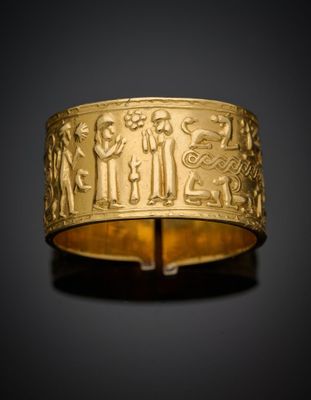 un bracelet en or orné de motifs représentant des personnes