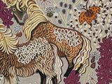 embroidered picture of two horses in a field of flowers with a lady bug in the background
