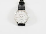 un gros plan d'une montre sur une surface blanche avec un fond blanc