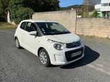 a small white car parked on the side of the road
