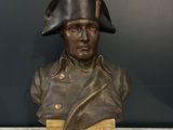 statue of a man wearing a hat and holding a wooden box