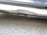 a close up of a car ' s bumper with a hole in it