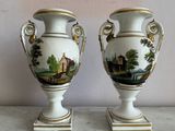 two vases sitting on a table with a painting on them