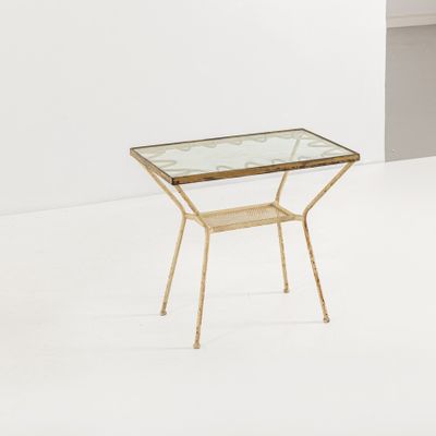 une table en verre avec des pieds dorés et un plateau en verre