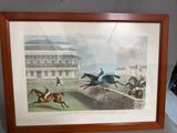 a framed picture of a horse race with jockeys and horses
