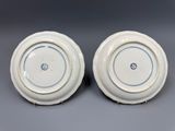 deux assiettes blanches bordées de bleu, posées sur une surface grise