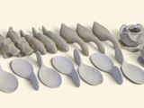 de nombreuses cuillères et spatules alignées sur une surface blanche